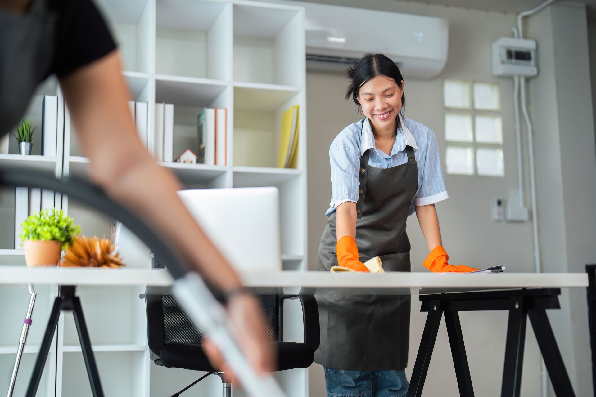 Asian woman cleaning in work room at home. Young woman housekeeper cleaner use a cloth to wipe equipment for working. concept housekeeping housework cleaning